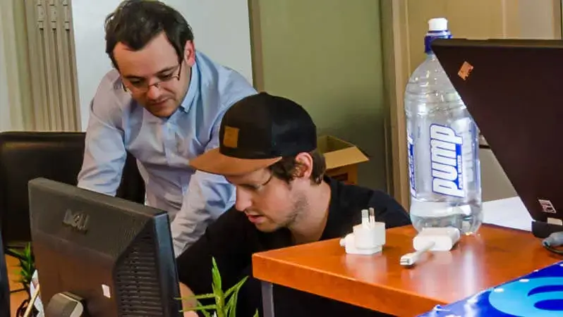 GTG Network co-founders Nathan Rothschild and Jared Hopping looking at monitor